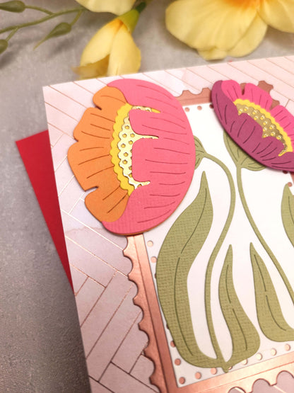 Světle růžové přání se sasankami a červenou obálkou